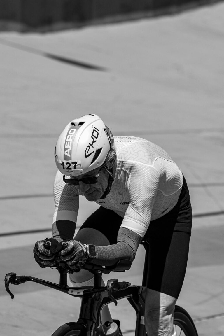 Black and white photo of a cyclist in a time trial race, focused and determined.