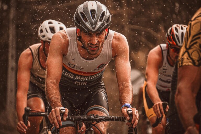 Determined athletes compete in a rain-soaked cycling race, pushing through with endurance.
